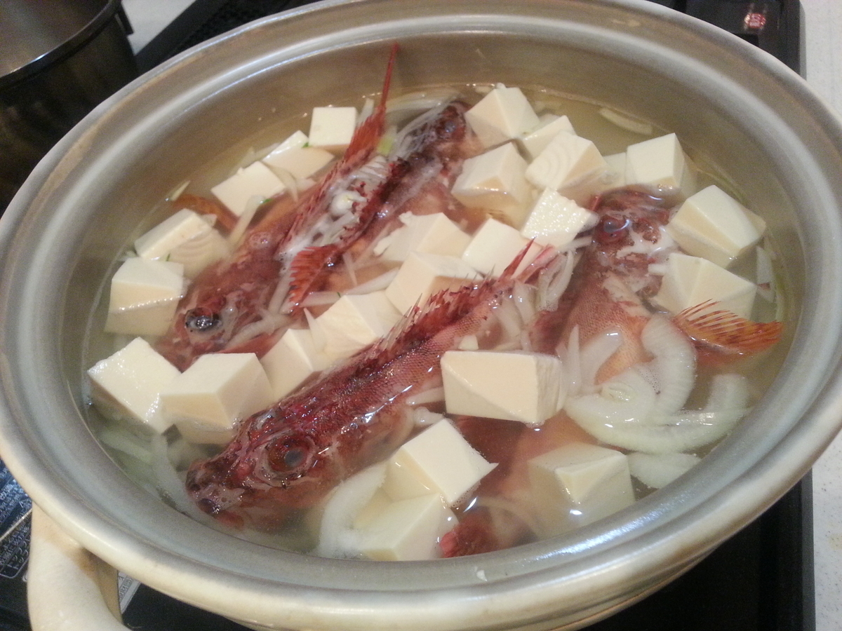 カサゴ、玉ねぎ、豆腐を鍋に入れた写真